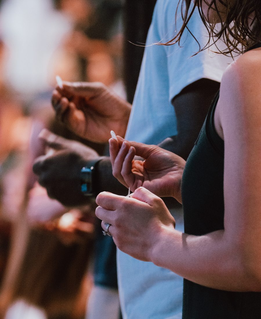 Hands holding communion elements in a row