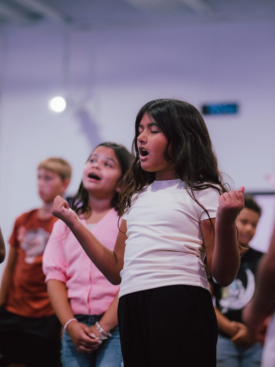 A girl singing with her eyes closed during worship